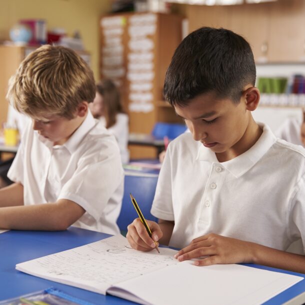 Two,Schoolboys,Working,In,A,Primary,School,Class,,Close,Up Male students working in the class